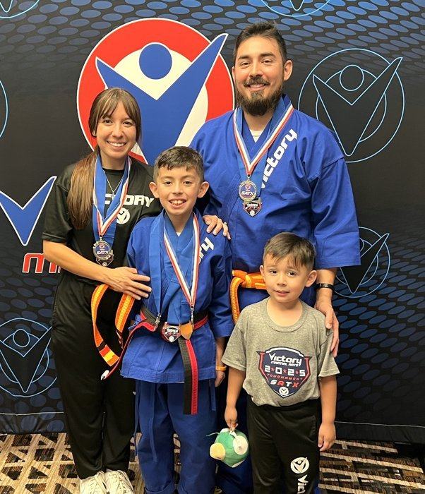 A mother and son flex their arms in matching belts