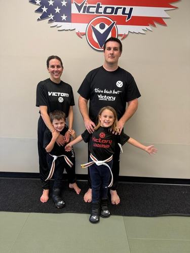 Parents and two kids pose in Victory shirts