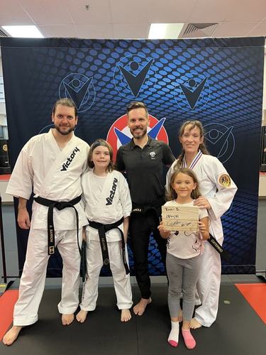 A family in uniforms with a certificate