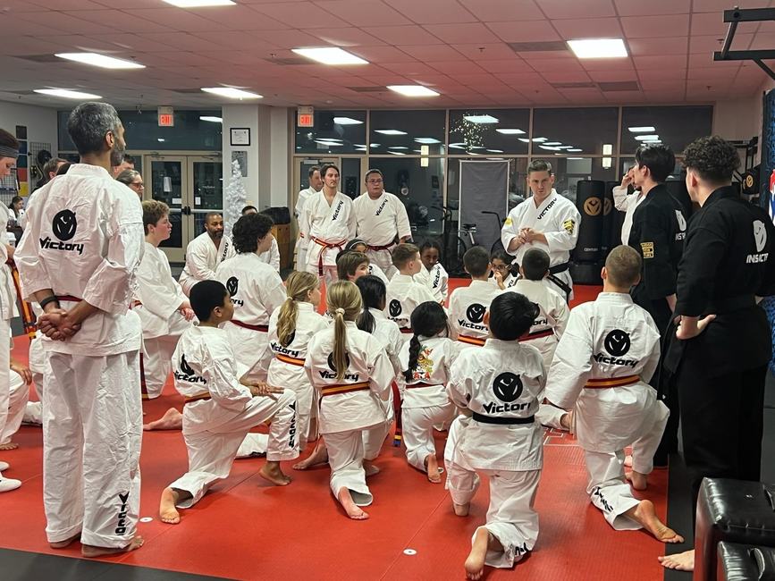 Students kneel in rows listening to their mentor