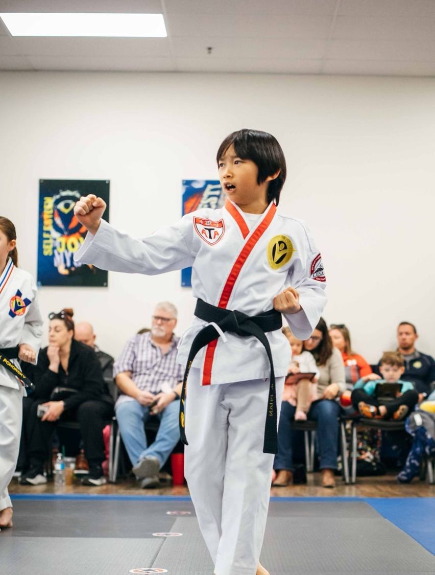 A girl holds a high kick and smiles